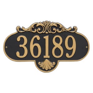 A house number sign with gold lettering and a black background.