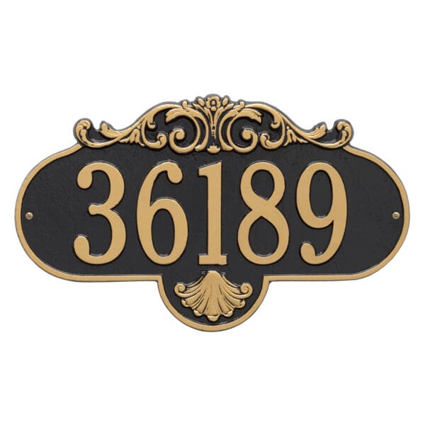 A house number sign with gold lettering and a black background.