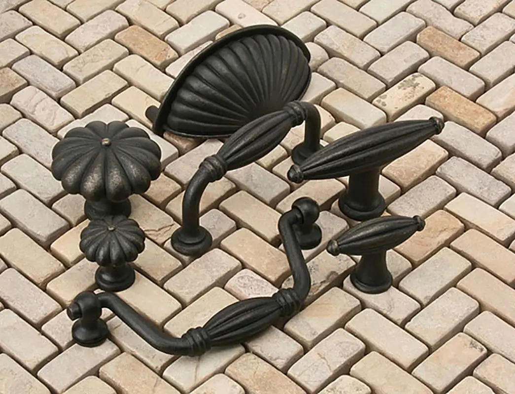 A set of four black knobs and handles on the ground.